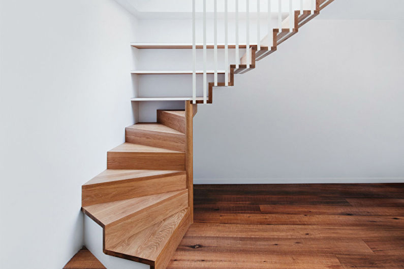 a wooden staircase in a room with white walls.