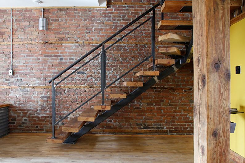 a staircase in a room with a yellow wall.