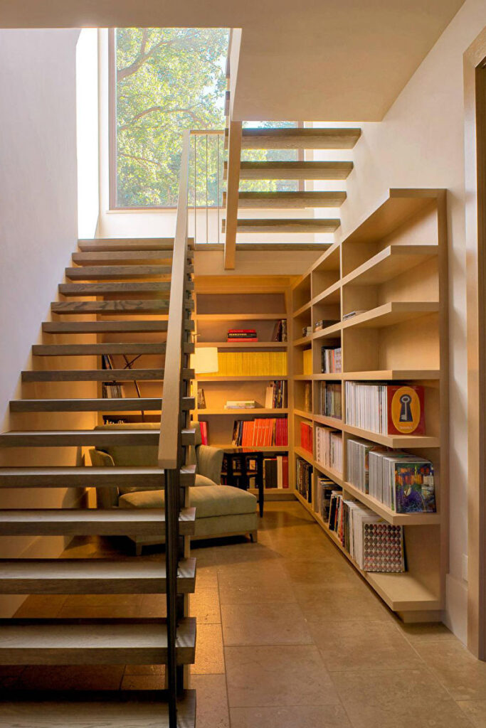 a staircase leading to a room with bookshelves.