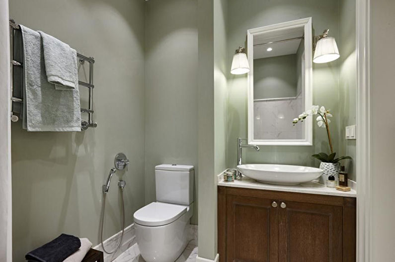 a bathroom with a toilet, sink and mirror.