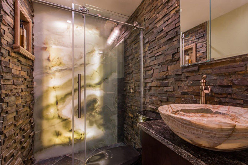 a bathroom with a stone sink and a glass shower stall.