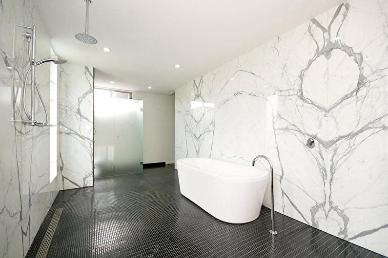 a bathroom with white marble walls and a bathtub.