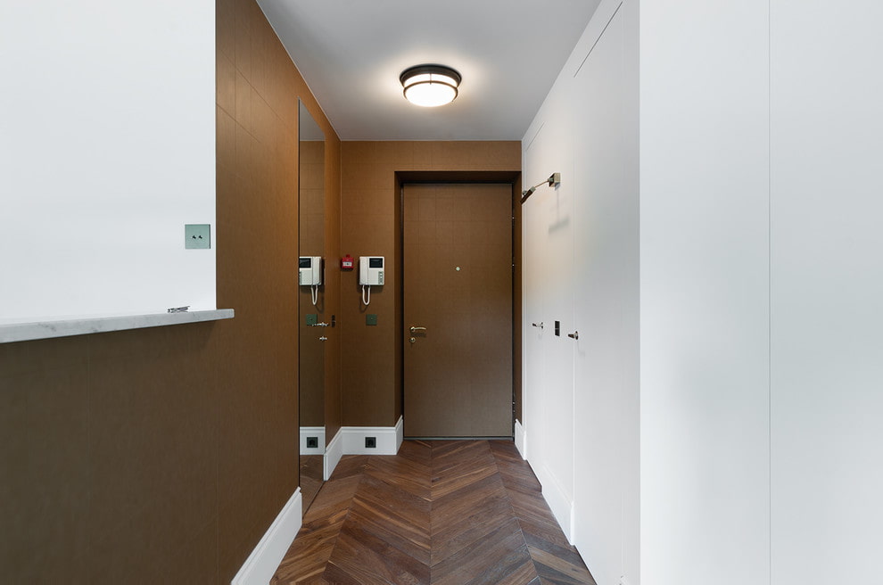 a hallway with a wooden floor and white walls.