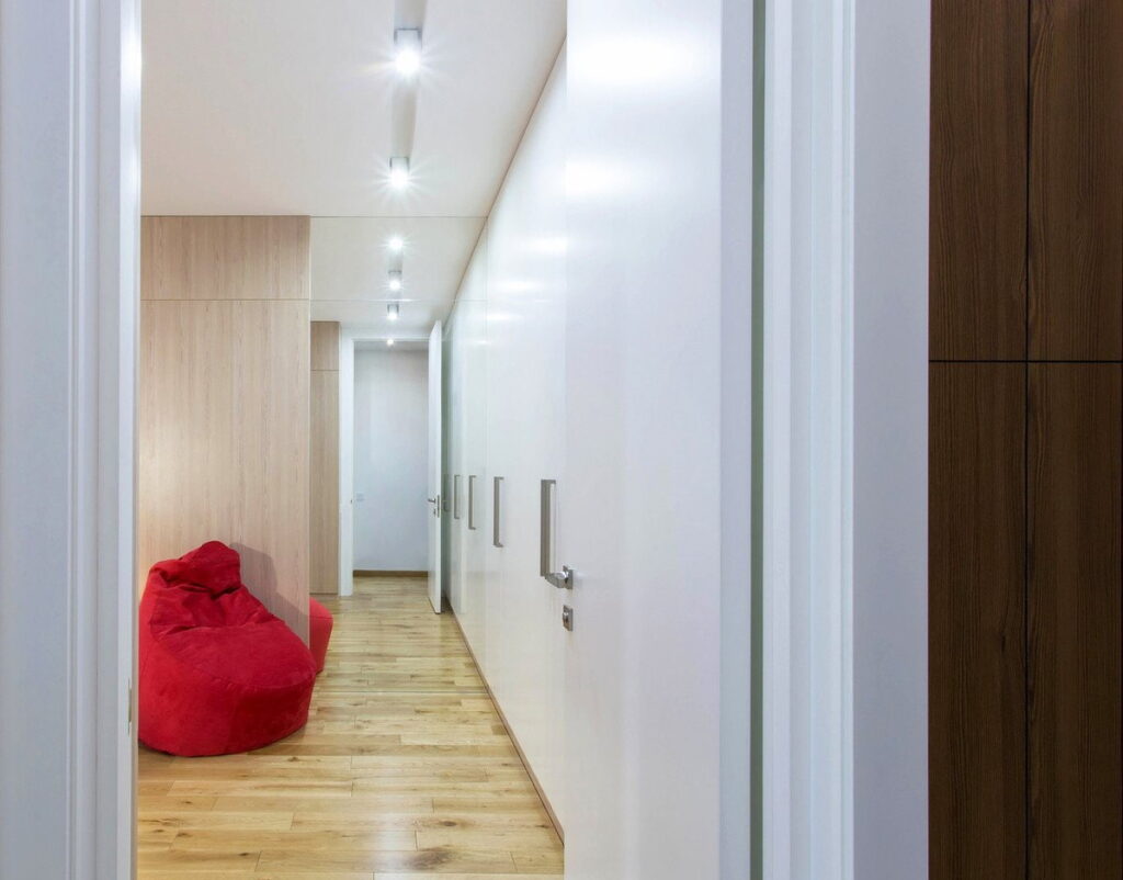 a hallway with wooden floors and a red bean bag chair.