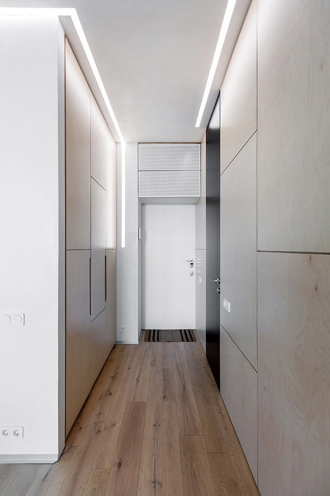 a hallway with wooden floors and white walls.