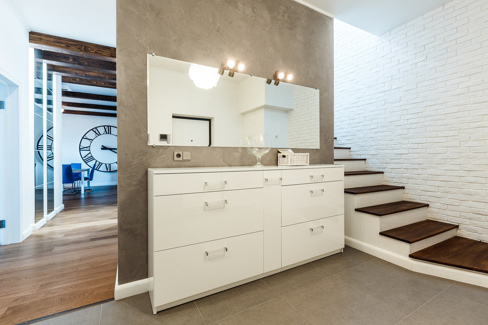 a white dresser with a clock next to it.