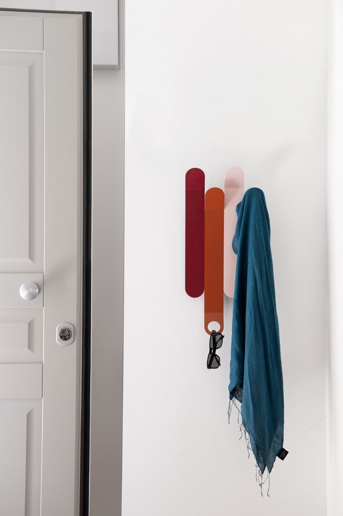 a wall mounted coat rack with a scarf hanging on it.