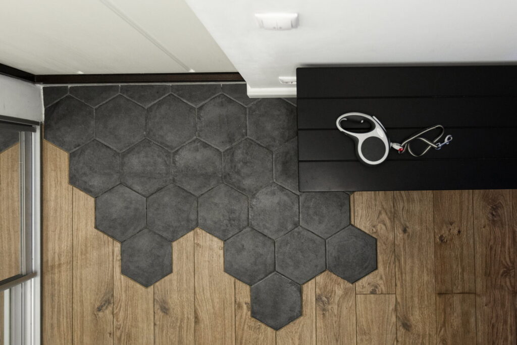 a black hexagon tile on a wooden floor.