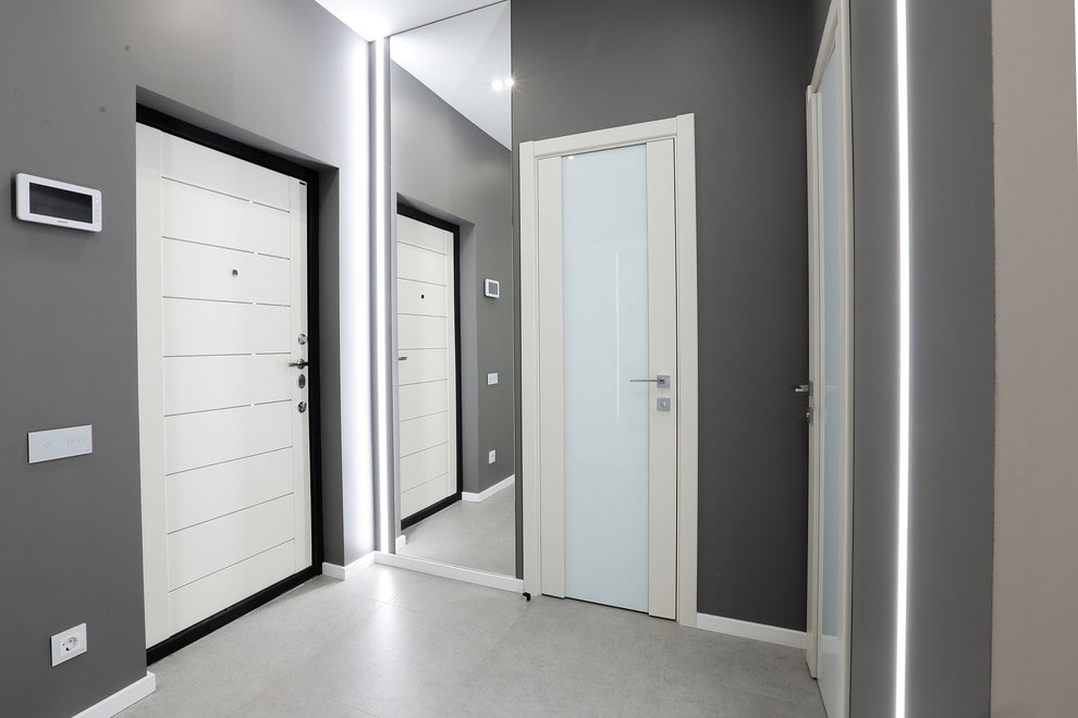 a hallway with white doors and gray walls.