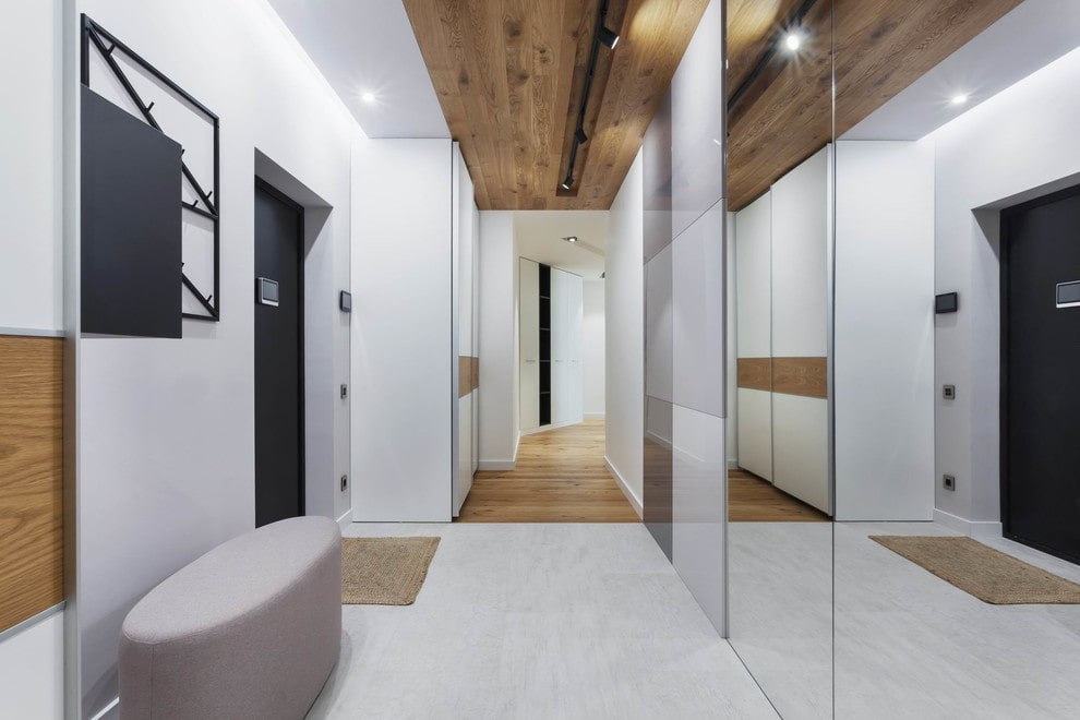 a hallway with a wooden ceiling and white walls.