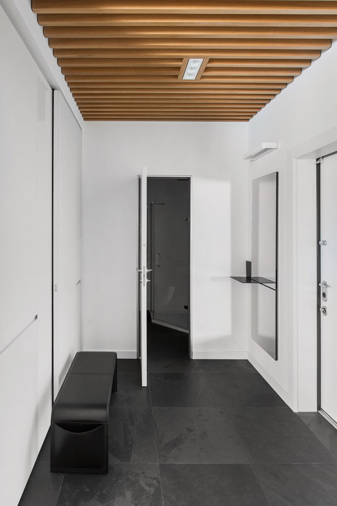 a hallway with a wooden ceiling and white walls.