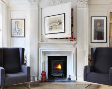 a living room with two chairs and a fireplace.
