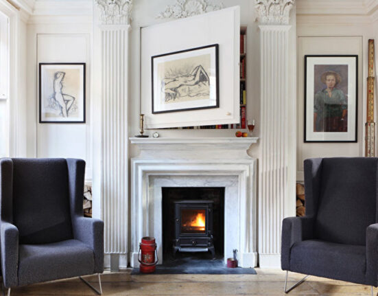 a living room with two chairs and a fireplace.