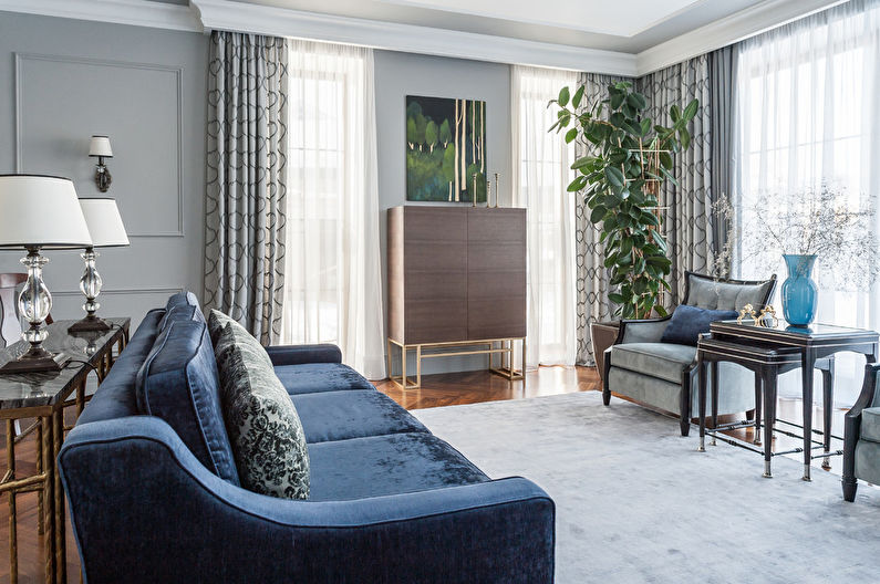 a living room with grey walls and blue furniture.