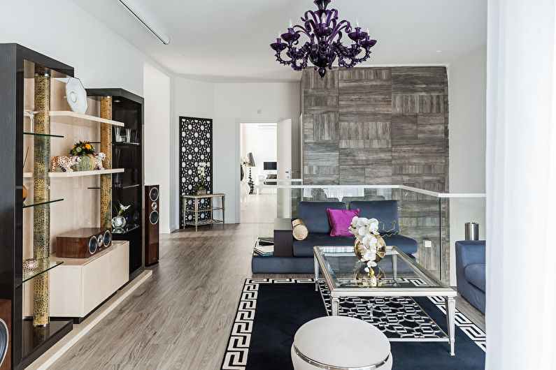 a living room with black furniture and a chandelier.