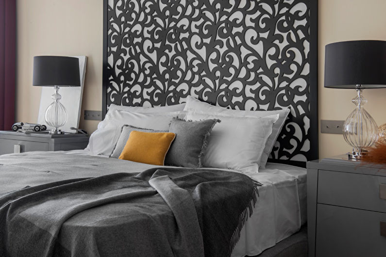 a bedroom with a black headboard and yellow pillows.