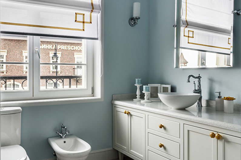 a bathroom with blue walls and gold accents.