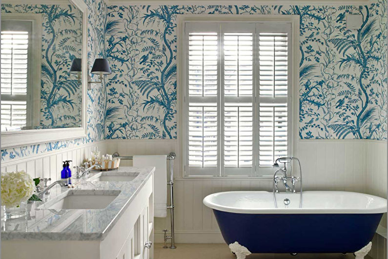 a bathroom with blue and white wallpaper and a bathtub.