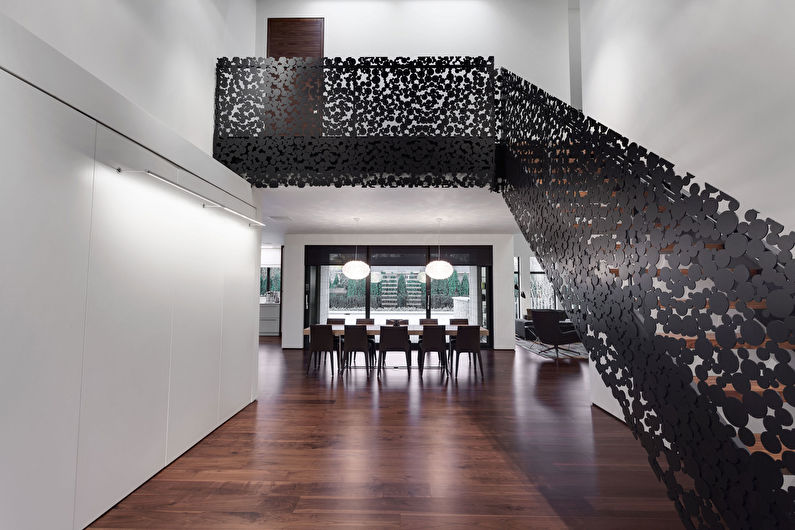 a staircase in a modern home with black metal railings.