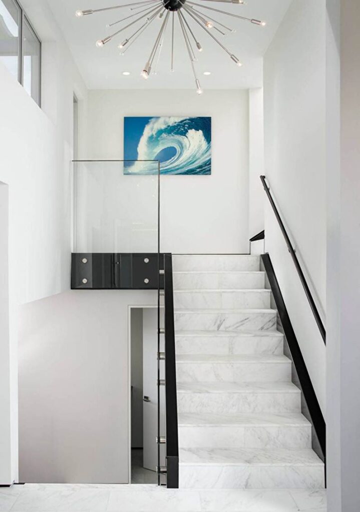 a modern staircase with a painting on the wall.