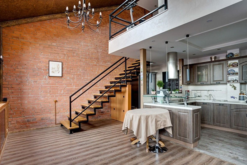 a kitchen with a staircase and a wooden floor.