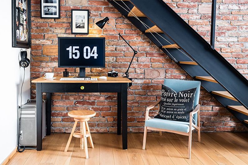 a room with a desk, chair and stairs.