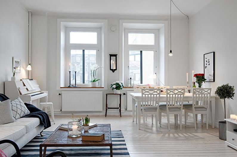 a living room with white furniture and a piano.