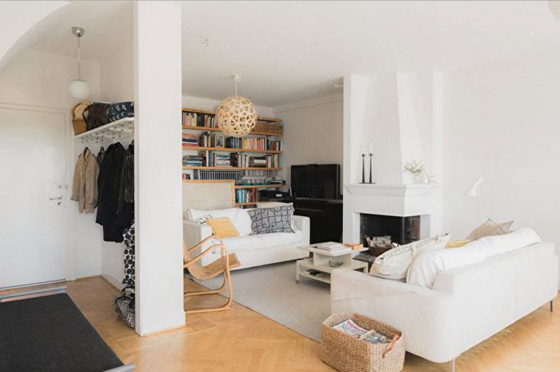 a living room with white furniture and bookshelves.