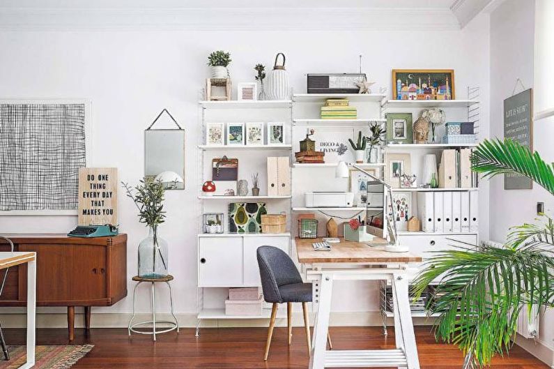 a home office with a desk, bookshelf and plants.