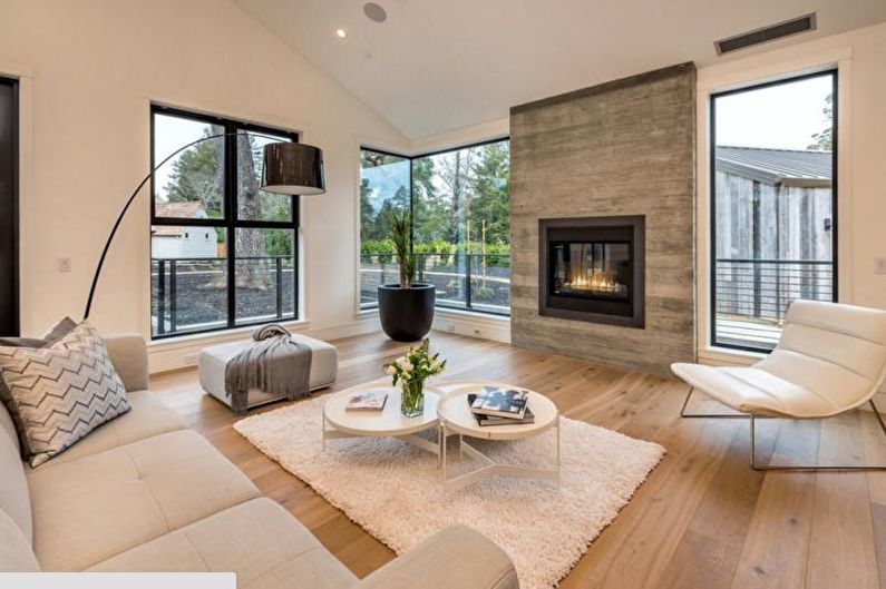 a living room with large windows and a fireplace.