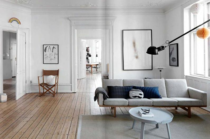 a living room with white walls and wooden floors.