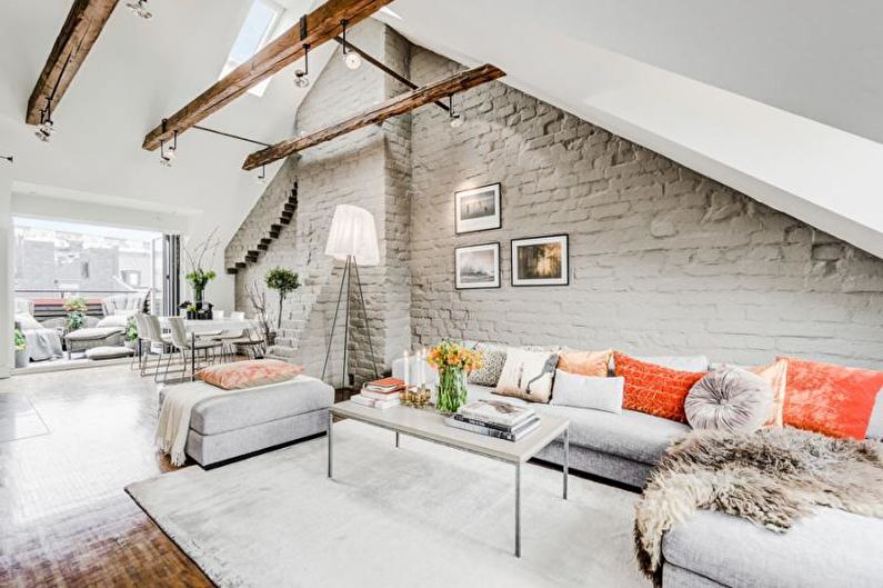 an attic living room with grey walls and wooden beams.