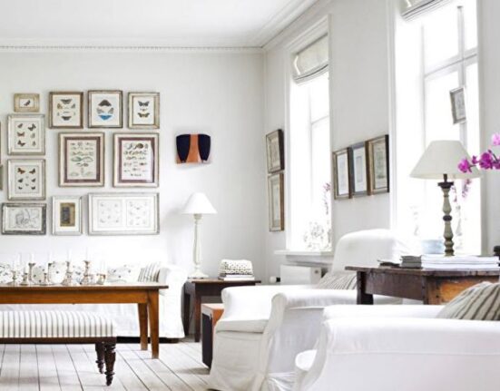 a white living room with lots of pictures on the wall.