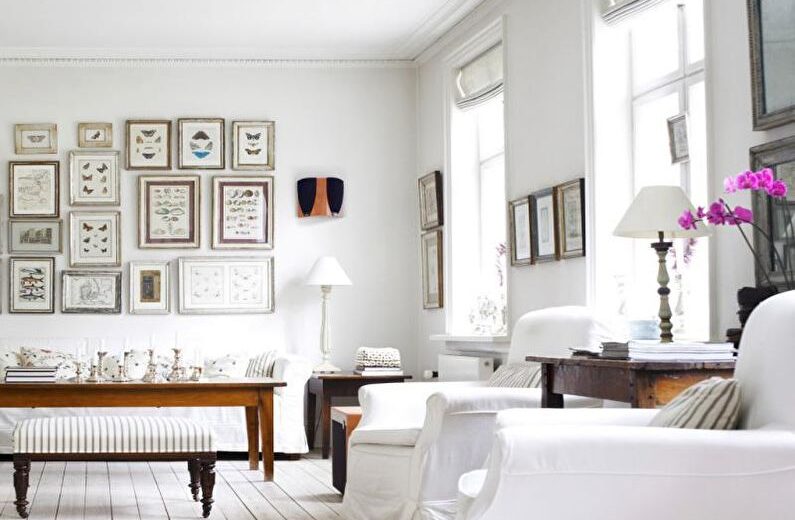 a white living room with lots of pictures on the wall.