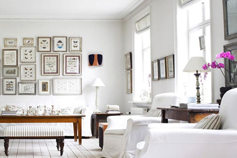 a white living room with lots of pictures on the wall.