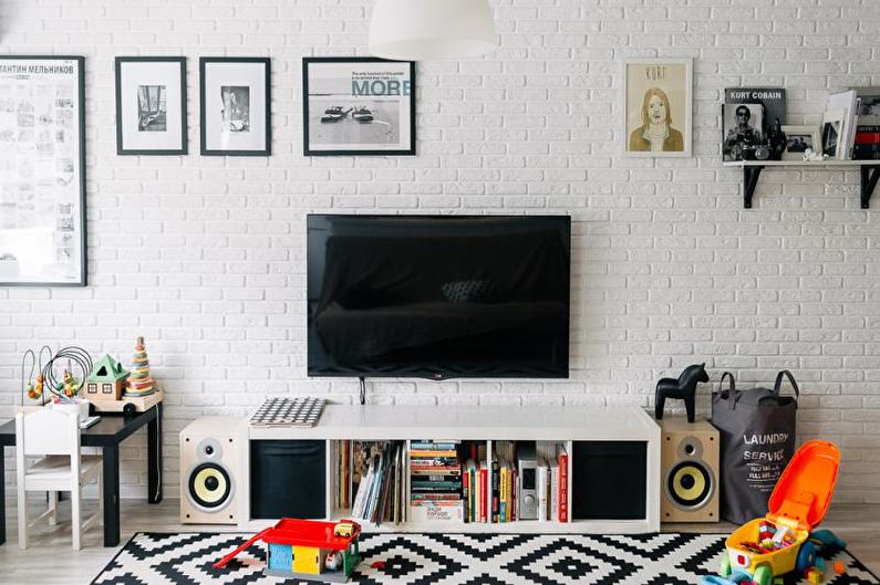 a living room with a black and white rug and a tv.