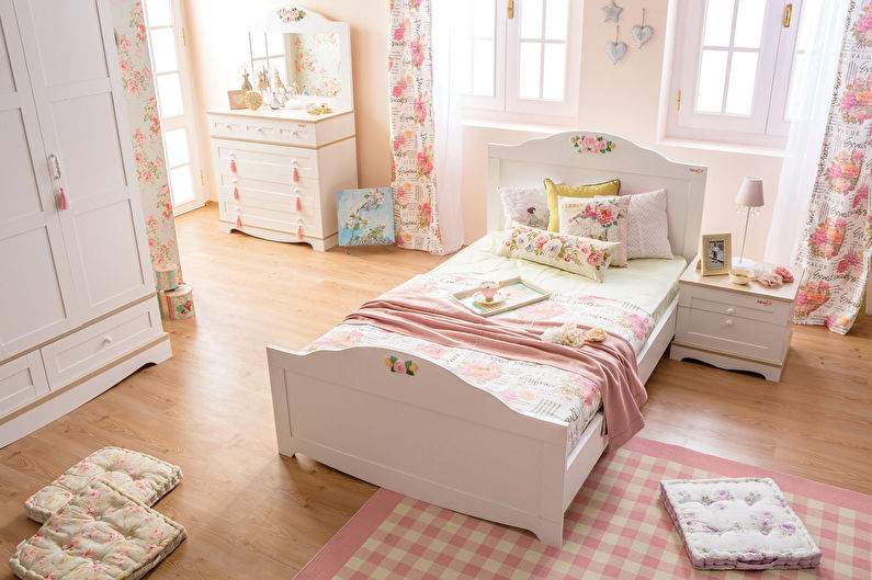 a pink and white bedroom with a bed and dresser.