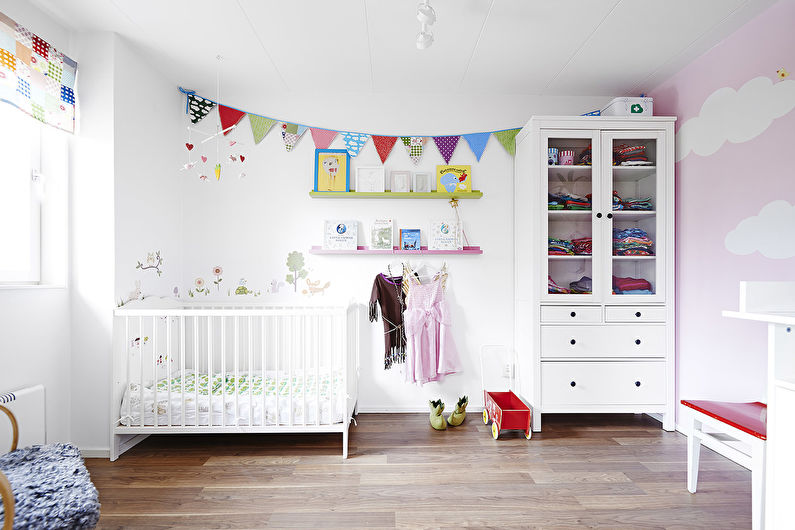 a pink and white baby room with a crib and dresser.