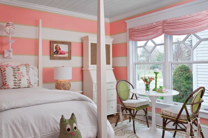 a girl's bedroom with pink and white striped walls.