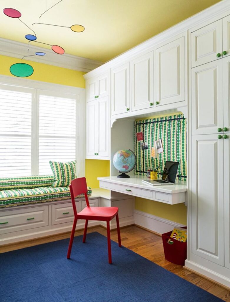 a child's room with yellow walls and a red chair.