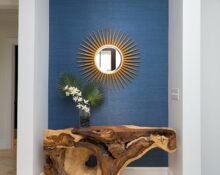 a wooden table in a hallway with a mirror on it.