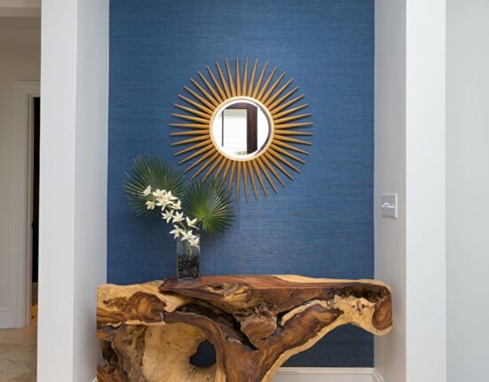 a wooden table in a hallway with a mirror on it.