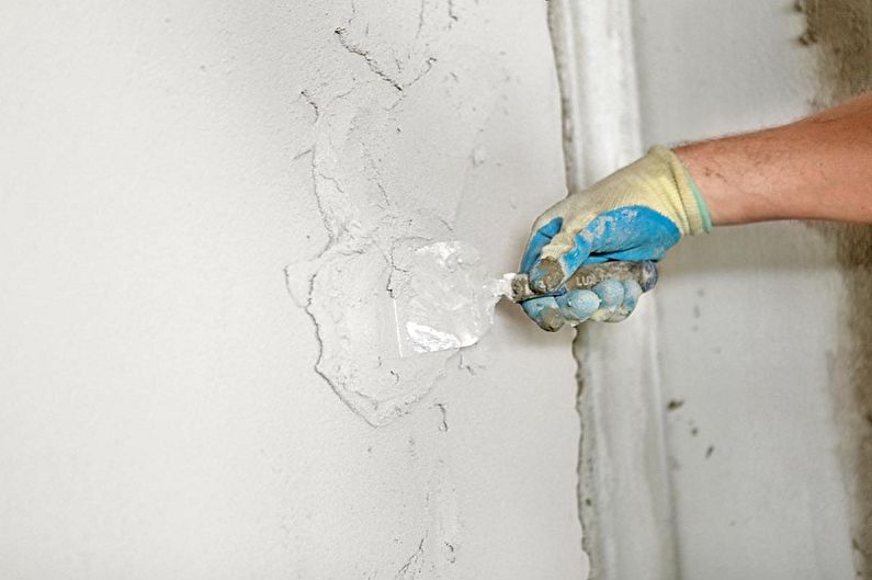 a man is putting cement on a wall.