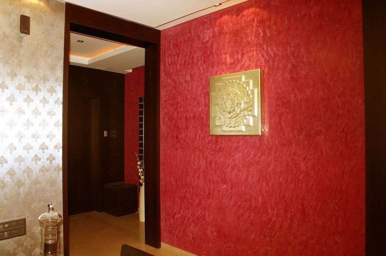 a hallway with red walls and a picture on the wall.