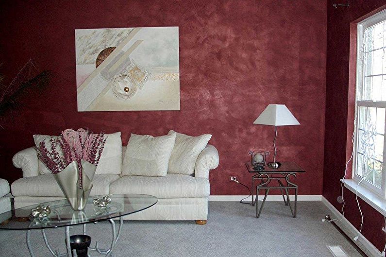 a living room with red walls and white furniture.