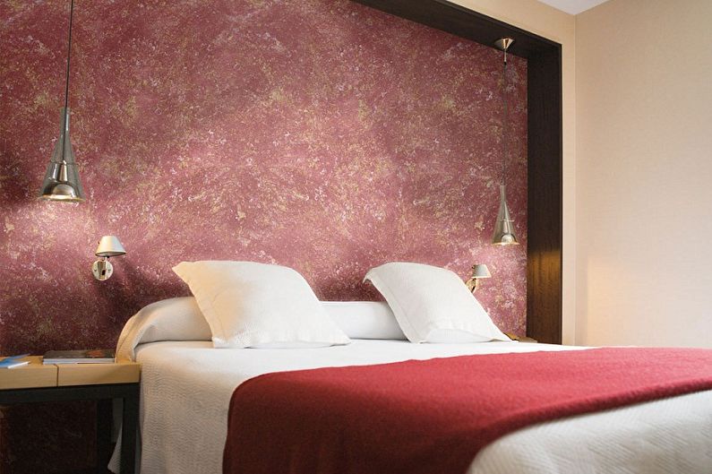 a bed in a hotel room with red walls.