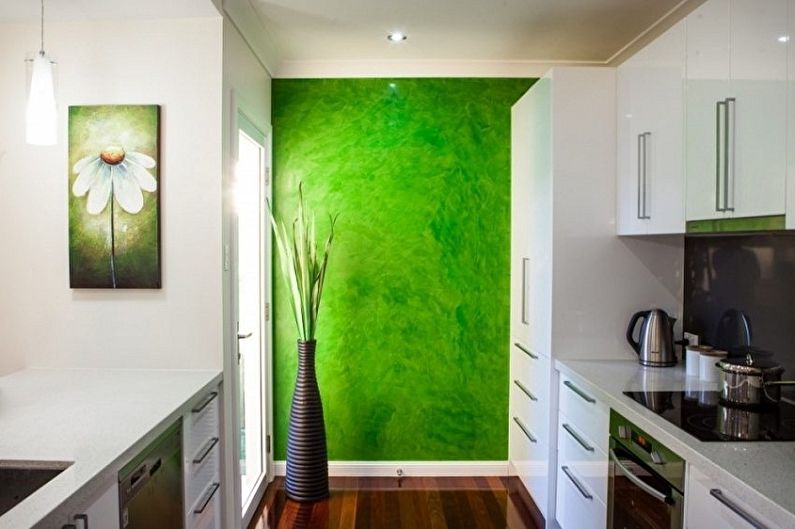 a kitchen with a green wall and white cabinets.