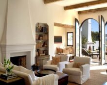 A living room with a fireplace and large windows.