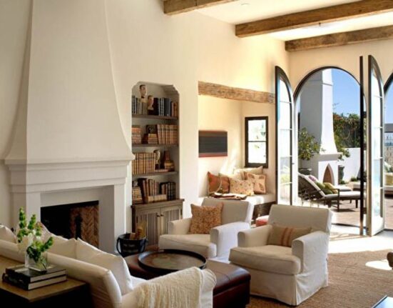 A living room with a fireplace and large windows.