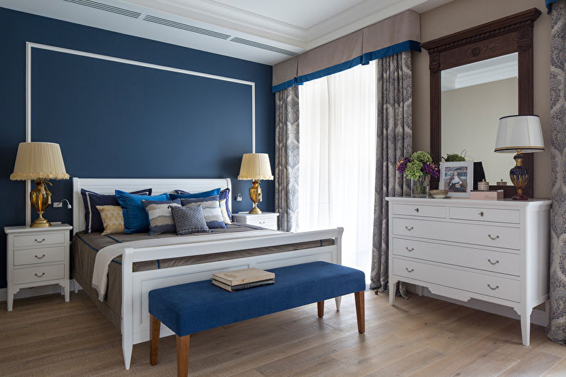 A bedroom with blue walls and white furniture.